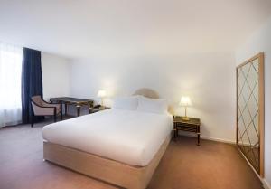 a hotel room with a white bed and a desk at Nottingham Place Hotel in London