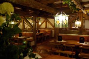 バート・ゲーグギングにあるHotel Centurioの木製のテーブルと椅子、シャンデリアのあるレストラン