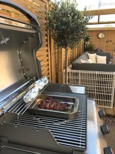 a grill with a tray of meat on a patio at The Old Dairy Malvern in Great Malvern