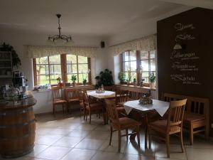 洛伊查赫的住宿－Hopfenhof，用餐室设有桌椅和窗户。