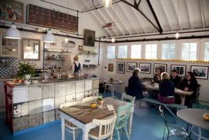 Plum Cottage - Vivre Retreats في ويمبورن مينستر: مجموعة من الأشخاص يجلسون على الطاولات في مطعم