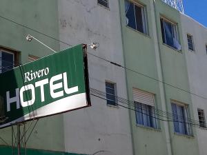 a sign for a hotel next to a building at Rivero Hotel in Chuí