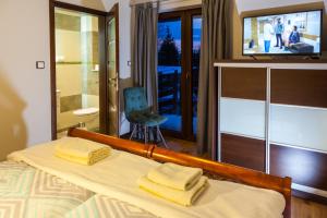 a bedroom with a bed with two towels on it at Gościniec Krutyński in Krutyń