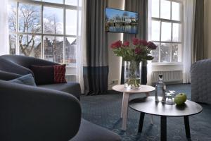 a living room with a vase of flowers on a table at De Nederlanden, Restaurant & Boutique Hotel in Vreeland