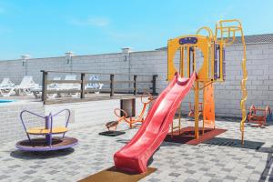 a playground with a red slide and chairs at SeaZone in Zatoka