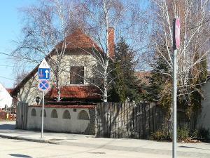 Vörös Macska Vendégház في Szentkirályszabadja: منزل على زاوية شارع فيه لافته