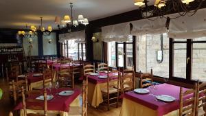 uma sala de jantar com mesas e cadeiras roxas em El RINCON ESPINOSA em Espinosa de los Monteros