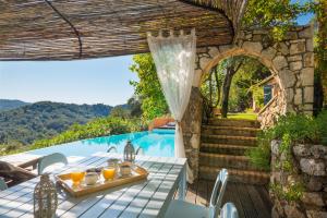 an outdoor patio with a table and a swimming pool at Villa Melolia in Ýpsos