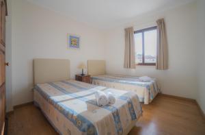 2 camas en una habitación con ventana en Marina Buzios by Garvetur, en Vilamoura