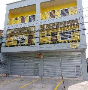 a building with two garage doors and a balcony at Entire flat 3rd floor in Lasip Chico