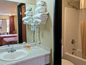 a bathroom with a sink and a mirror and towels at Americas Best Value Inn - Augusta / South in Augusta