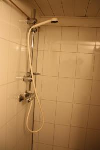 a shower with a hose in a bathroom at Heddan Gjestegard in Tingvatn