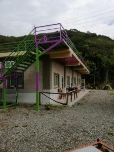 a building with a purple and green staircase on it at 台東民宿 關山桃花心木民宿農場 in Guanshan