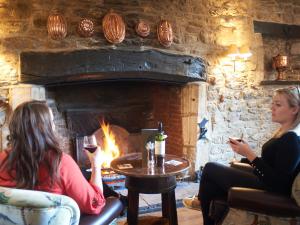 two women sitting in a room with a fireplace at Bear and Ragged Staff in Oxford