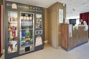 uma mercearia com um refrigerador de bebidas numa loja em Kyriad Sannois - Ermont em Sannois