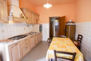 uma cozinha com uma mesa e um fogão forno superior em Appartamento Pomonte la Posta - Goelba em Pomonte