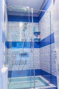 a shower stall with a blue and white shower curtain at Brigantina Hotel in Lyudinovo