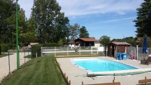 a swimming pool in a yard with a fence at Paradis Des Dombes in Sandrans