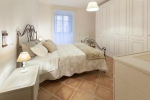 ein Schlafzimmer mit einem Bett und einem Tisch mit einer Lampe in der Unterkunft Canto XI in Assisi