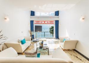 uma sala de estar com mobiliário branco e uma televisão em Zoetry Villa Rolandi Isla Mujeres Cancun - All Inclusive em Ilha das Mulheres