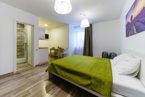 a bedroom with a bed with a green blanket at Riga Airport Jurmala apartments in Rīga