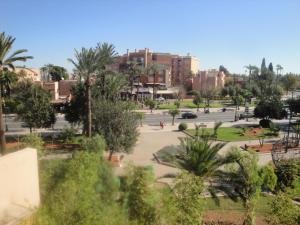 a view of a park with palm trees and buildings at La Fontaine in Marrakesh