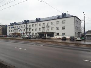 ein großes weißes Gebäude an der Straßenseite in der Unterkunft Sandra apartamentai in Kaunas