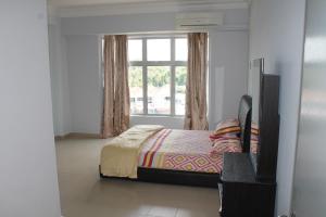 a bedroom with a bed and a window at Ocean View Resort in Port Dickson