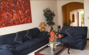 a living room with two blue couches and a table at Suites Colibri in Oaxaca City