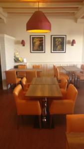 a dining room with tables and orange chairs at Hotel Restaurant Le Parc in Moulins