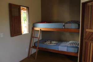 two bunk beds in a room with a window at Family Guest House in Ilha de Boipeba