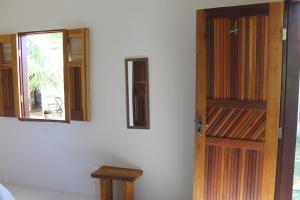 a room with a wooden door and a window at Family Guest House in Ilha de Boipeba
