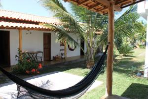 a hammock in front of a house at Family Guest House in Ilha de Boipeba