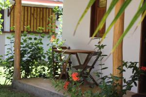 a wooden table sitting on the porch of a house at Family Guest House in Ilha de Boipeba