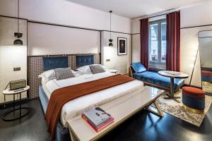 Locanda Pandenus Brera في ميلانو: غرفة نوم بسرير كبير وكرسي ازرق