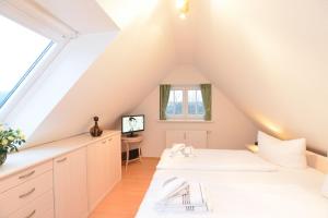 two beds in a attic room with a window at App-Syltperle in Westerland (Sylt)