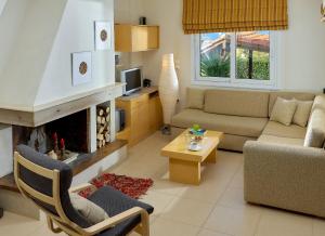 a living room with a couch and a fireplace at Spacious villa with private eco-pool and panoramic sea view in Agia Pelagia