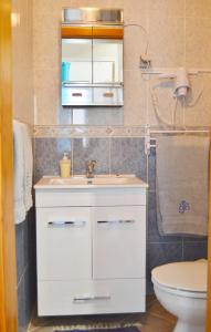 a bathroom with a white sink and a toilet at BJB - Alojamentos in Olhão