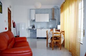 a living room with a couch and a table and a kitchen at BJB - Alojamentos in Olhão