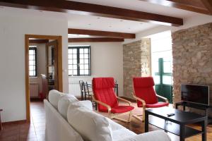 sala de estar con sofá y sillas rojas en Casa Pedrosa, en Mondoñedo