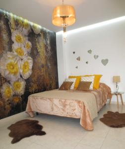 - une chambre avec un lit et un mur fleuri dans l'établissement Golden Dreams & Perfect for you *****, à Adeje