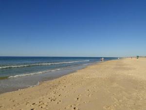 een strand met mensen die over het zand en de oceaan lopen bij Casa São José by Pérola do Oceano in Manta Rota