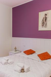 sypialnia z 2 łóżkami i fioletową ścianą w obiekcie GuestHost - Istria M5 Cozy Apartment w Mediolanie
