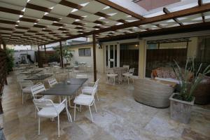 d'une terrasse avec une table, des chaises, des tables et des chaises. dans l'établissement Hotel La Pergola, à Alba Adriatica
