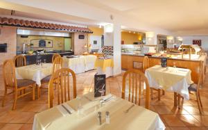 un restaurante con mesas y sillas y una cocina en JS Cape Colom - Adults Only, en Portocolom