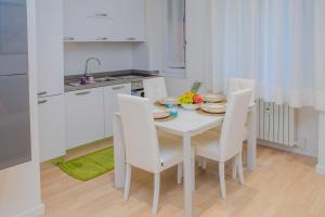 米蘭的住宿－Niguarda & Bicocca Flat，厨房配有白色的桌子和白色的椅子