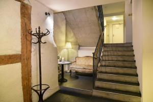 a hallway with a staircase with a chair and a couch at Hotel Hirschen in Zürich