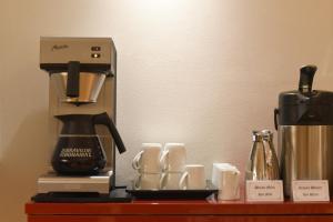 a coffee maker and cups on a table at Hotel Hirschen in Zürich