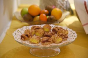 a plate of pastries on a table with a bowl of fruit at Hotel Hirschen in Zürich