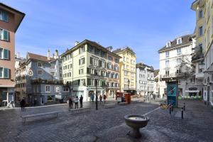 a city street with many buildings and a fountain at Hotel Hirschen in Zürich